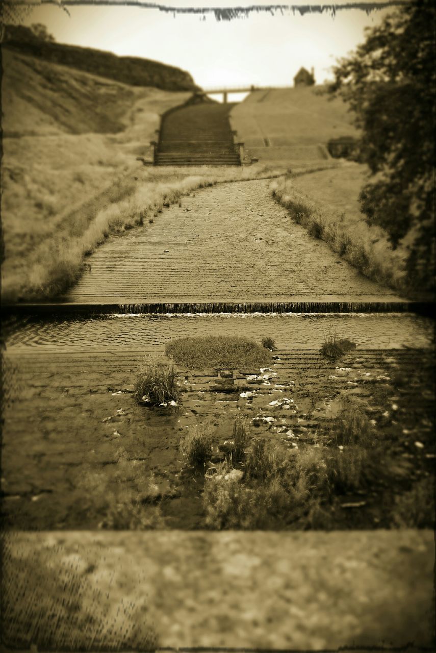 transfer print, auto post production filter, landscape, field, tranquil scene, tranquility, sky, nature, sand, grass, surface level, day, selective focus, outdoors, no people, rural scene, road, non-urban scene, sunlight, the way forward