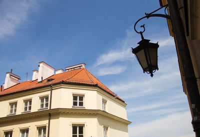 Low angle view of street light by building against sky