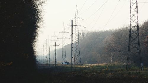 Electricity pylon on field against sky