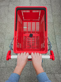 High angle view of woman holding red shopping cart