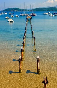 Sailboats moored on sea against sky