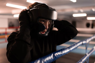 Powerful boxer adjusting safety helmet before fight