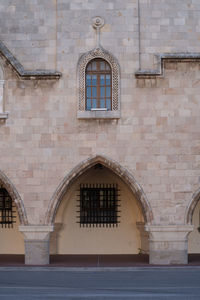 Window arch and column of an old  church.decorated with cement paintings of the ancient greeks.