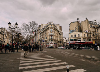 People walking on street against sky