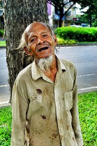 Portrait of man on tree trunk