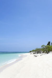 Scenic view of beach against clear blue sky