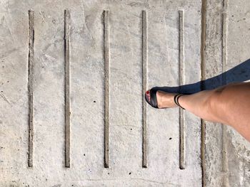 Leg of woman standing on concrete wall