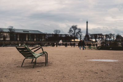 Empty chairs and tables against buildings in city