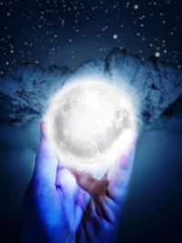 Digital composite image of hand holding crystal ball