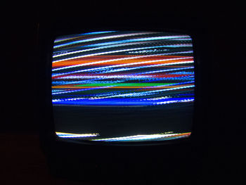 Close-up of illuminated lighting equipment against black background