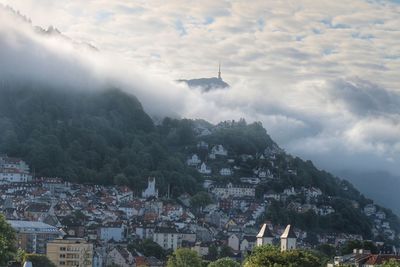 Aerial view of townscape and mountain against sky