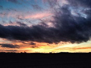 Silhouette of landscape against cloudy sky