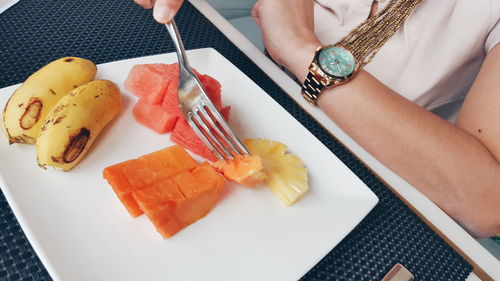 High angle view of hand eating from plate