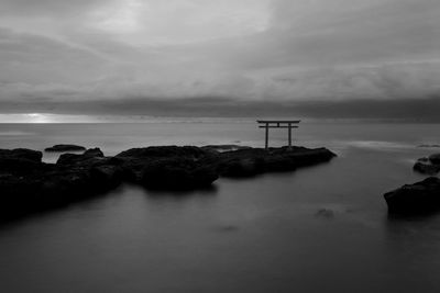 Scenic view of rocks in sea against sky