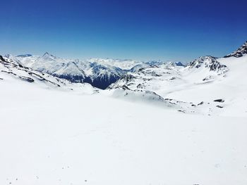 Scenic view of snowcapped mountains against clear blue sky