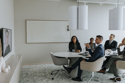 Business colleagues discussing strategy through video conference in board room