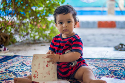 Portrait of cute boy sitting outdoors