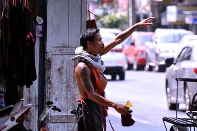 Side view of woman using mobile phone while standing outdoors