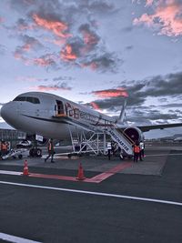 Airplane on airport runway against sky