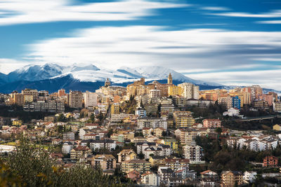 Aerial view of townscape and mountains against sky