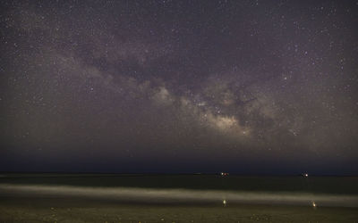 Scenic view of sea against star field at night