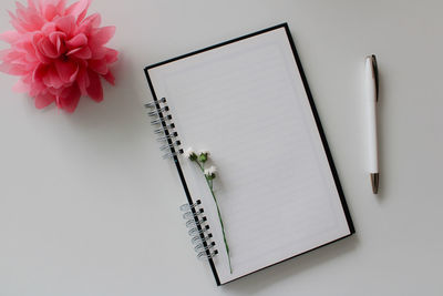 Directly above shot of book with pencil on white background