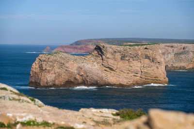 Scenic view of rocks in sea against sky