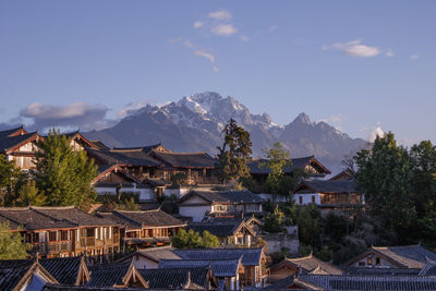 Houses in town against cloudy sky