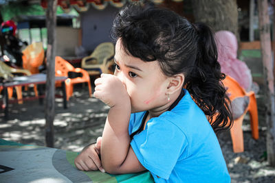 Portrait of cute girl sitting outdoors