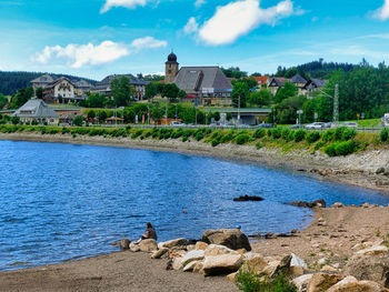 Scenic view of lake by buildings against sky