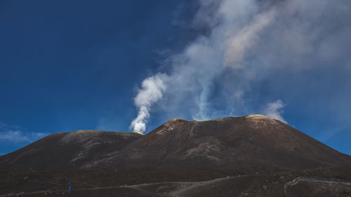 Low angle view of mountain against blue sky