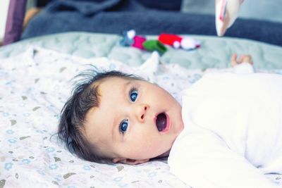 Portrait of cute baby lying on bed