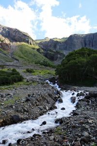 Scenic view of waterfall and mountains against sky