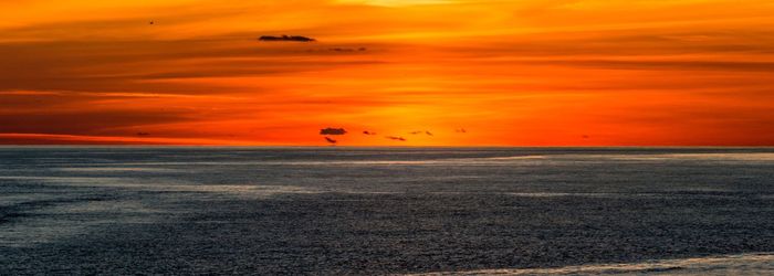 Scenic view of sea against orange sky