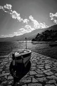 Boat moored on shore against sky