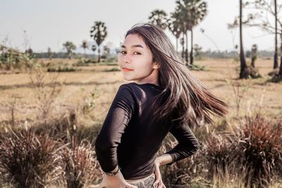 Beautiful young woman standing on field