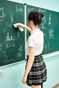Asian high school girl solves geometry on the blackboard