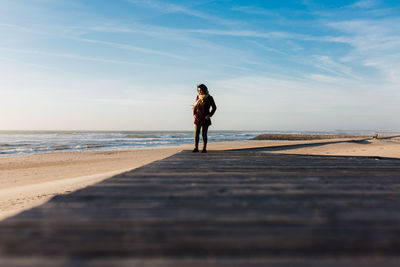 Woman standing on footpath at beach