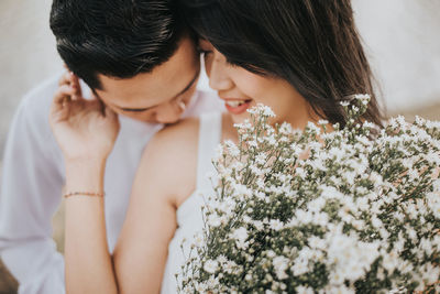 Young couple with white flowers romancing outdoors