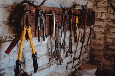 Close-up of various work tools hanging on wall in workshop