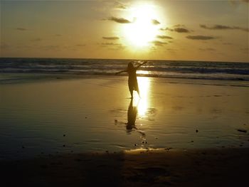 Silhouette people on beach during sunset