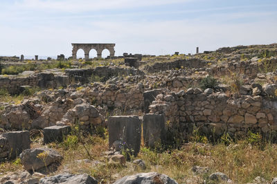 View of old ruin on field against sky