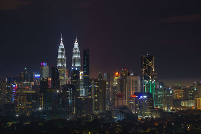 Illuminated buildings against sky at night