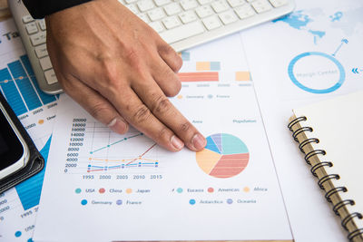 Close-up of businessman pointing at graph on table