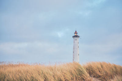 Lighthouse by sea against sky