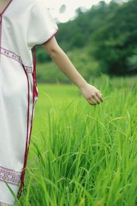 Midsection of woman standing on field