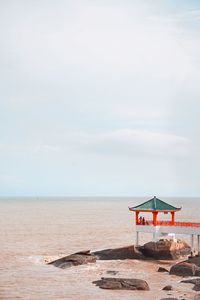 Lifeguard hut on beach against sky