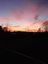 Silhouette trees against sky at sunset