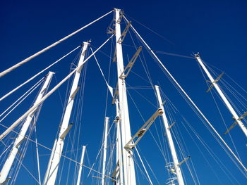 Low angle view of sailboats against clear blue sky