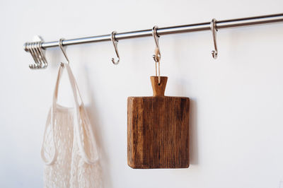 Close-up of clothespins hanging on clothesline against wall